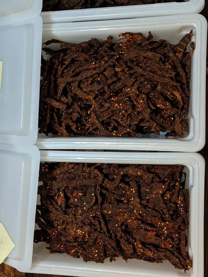 Trays of freshly smoked small-batch beef jerky with red chili pepper flakes