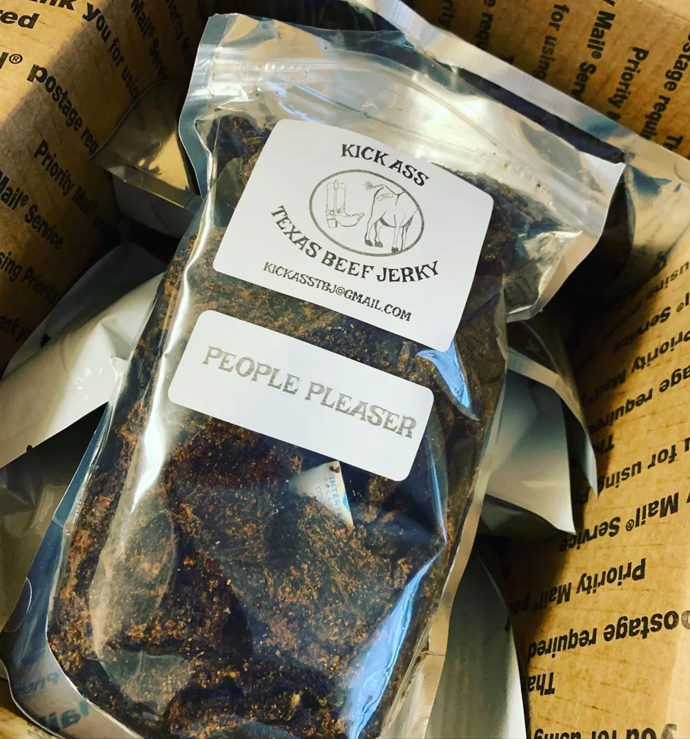 Bags of Kick Ass Texas Beef Jerky packed in a USPS Priority Mail shipping box
